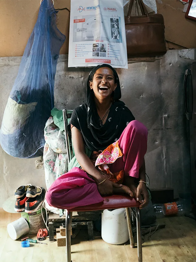 A young woman sits on a chair, smiling (Photo)