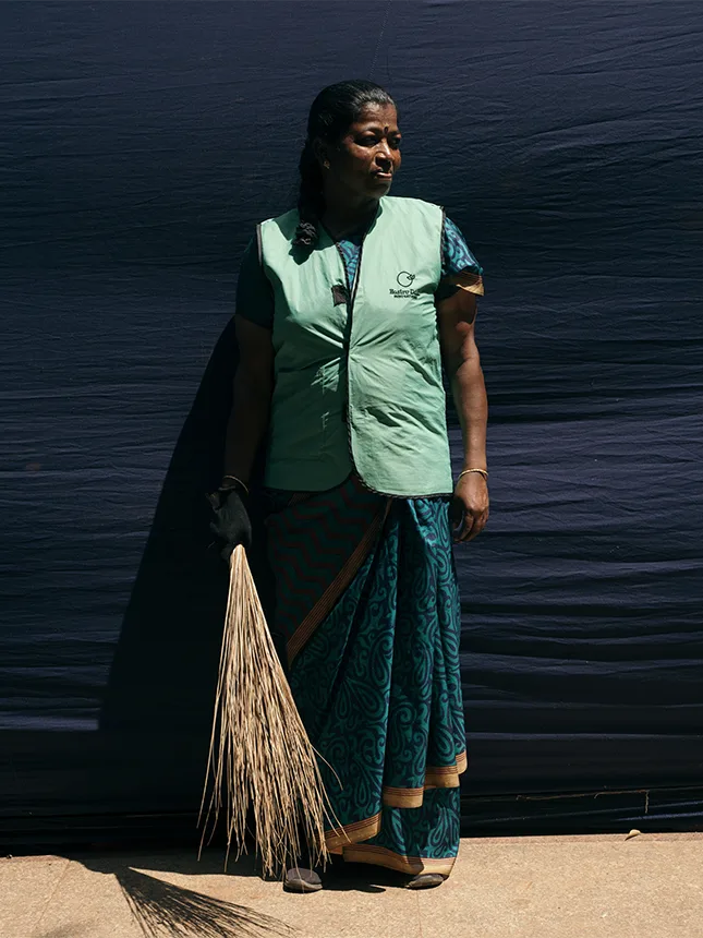 A woman in a safety vest holds a bunch of dried grasses (Photo)