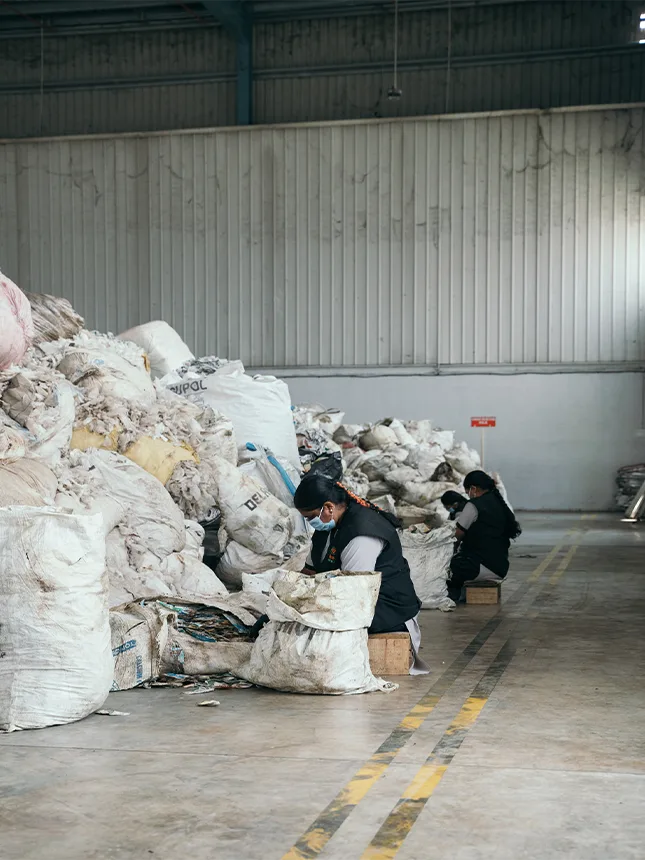 Women process sacks full of recycling materials (Photo)