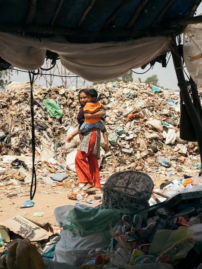 A woman with a child at a landfill site (Photo)