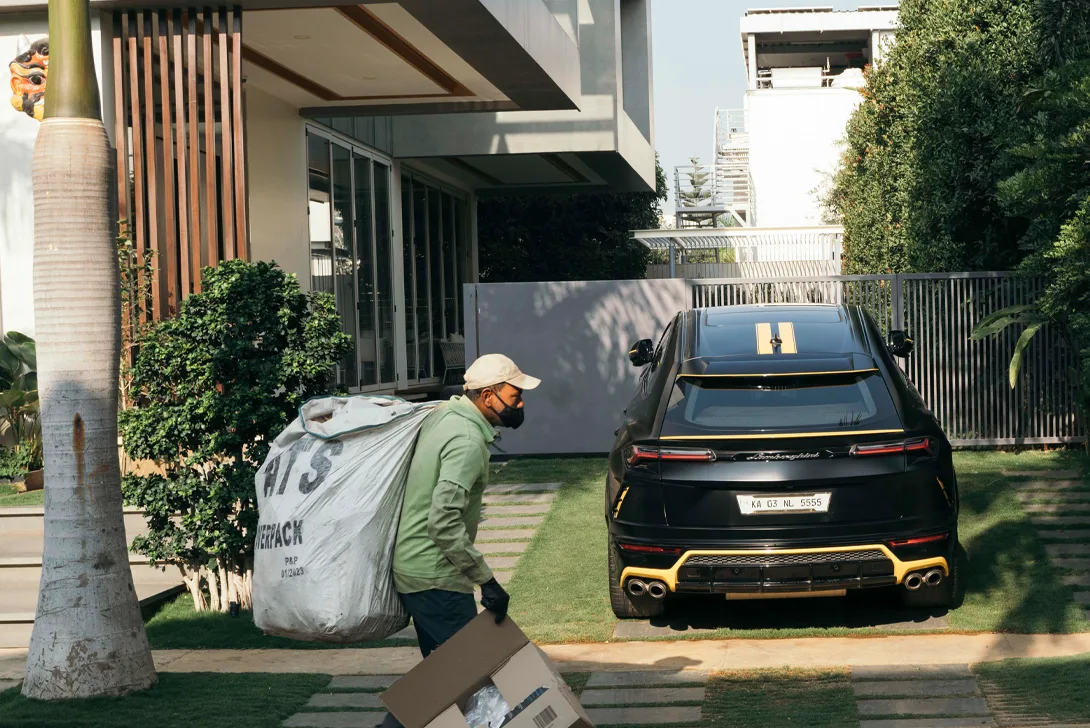 A man carries a large sack in front of a modern house (Photo)