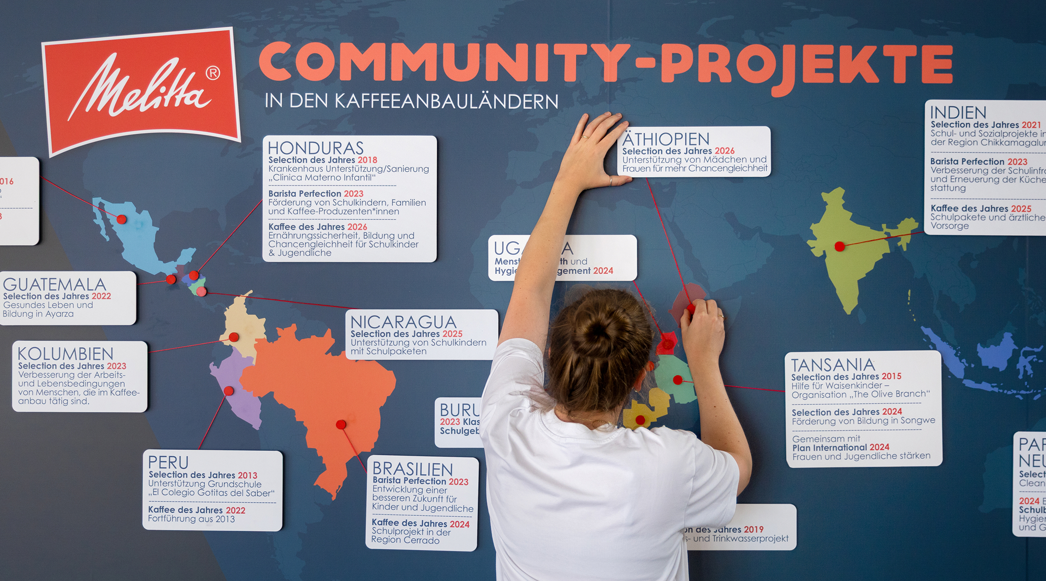 Protagonist attaches a sign labeled Ethiopia to Melitta&rsquo;s world map of community projects in coffee-growing countries.