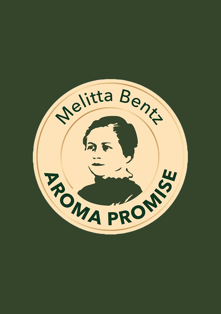 Round seal with portrait of Melitta Bentz and wording "Aroma Promise" on dark green background, quality mark for coffee.
