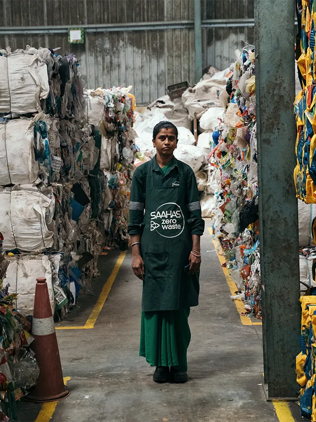 Eine Frau steht in einer Recyclinganlage (Foto)