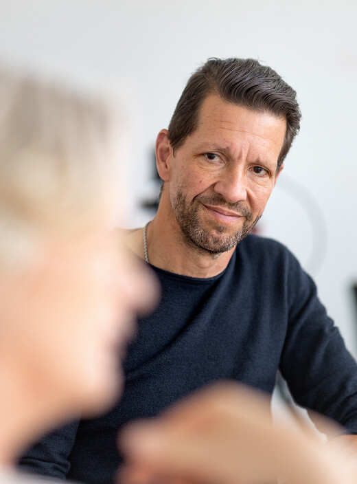 Portrait von Jero Bentz, der Katja M&ouml;ller aufmerksam zuh&ouml;rt. 