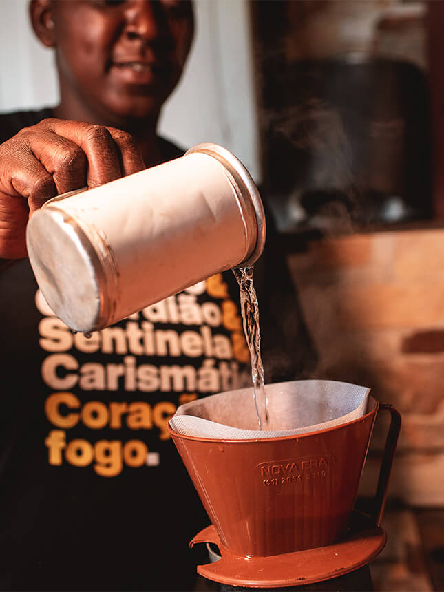 Eine Person schenkt Kaffee in eine Tasse ein