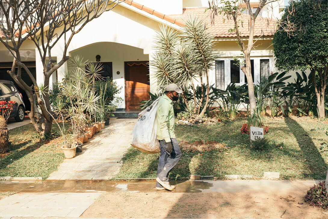 A man carrying a trash bag